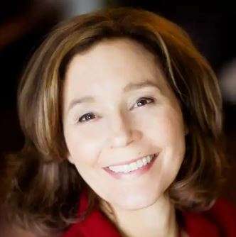 A smiling woman with brown hair and a red top, showcasing a friendly and approachable demeanor, ideal for personal branding and professional profiles.