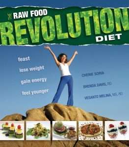 A woman stands triumphantly on a rock under a blue sky. The text reads The Raw Food Revolution Diet, promoting this plant-based lifestyle to feast, lose weight, gain energy, feel younger. Various raw food dishes are displayed at the bottom.