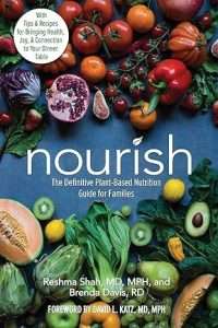 A vibrant book cover showcases a bounty of fruits and vegetables, including tomatoes, lettuce, avocado, and oranges. The title nourish: The Definitive Plant-Based Nutrition Guide for Families by Dietitian Reshma Shah and Brenda Davis takes center stage.